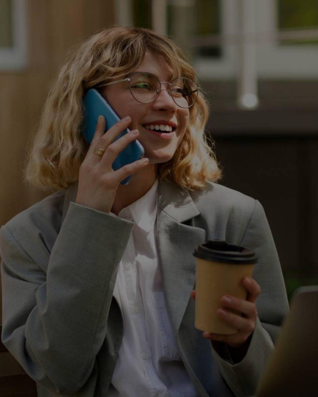 Mulher sorrindo com copo de café na mão